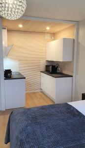 a kitchen with white cabinets and a bed in a room at Myplace in Oulu Studio Koulukatu in Oulu