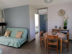 a living room with a table and a couch at Gîte Le Cherche Midi in Gaillac