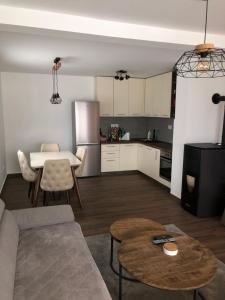 eine Küche und ein Wohnzimmer mit einem Sofa und einem Tisch in der Unterkunft Guest house Elena in Mojkovac