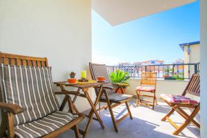 eine Terrasse mit Stühlen, einem Tisch und einem Balkon in der Unterkunft Apartman Gaby in Trogir