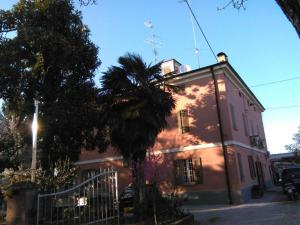 eine Palme vor einem rosa Gebäude in der Unterkunft b&blequercedimarco Camera Rossa in San Prospero 