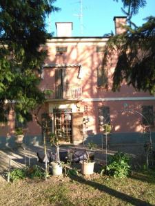 ein rosafarbenes Gebäude mit Topfpflanzen davor in der Unterkunft b&blequercedimarco Camera Rossa in San Prospero 