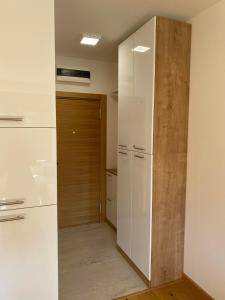 cocina con armarios blancos y puerta de madera en Jellenaa, en Zlatibor
