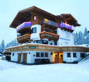 a large building with snow on the ground at Schickster Sky Lodge in Leutasch