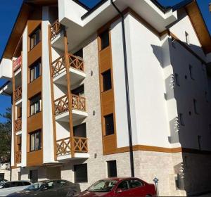 Un edificio con dos coches aparcados delante. en Jellenaa, en Zlatibor