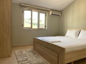 a bedroom with a large bed with a window at Cozy GuestHome Korce in Korçë
