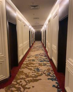 un couloir d'un hôtel avec un couloir recouvert de moquette dans l'établissement Temandra Hotel, à Djeddah