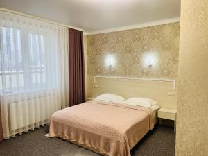 a hotel room with a bed and a window at Готель Лаванда in Khmelʼnytsʼkyy