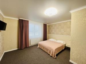 ein Hotelzimmer mit einem Bett und einem Fenster in der Unterkunft Готель Лаванда in Chmelnyzkyj