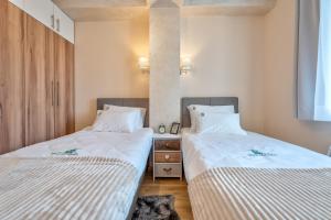 two beds sitting next to each other in a room at Bella Gondola Zlatibor in Zlatibor