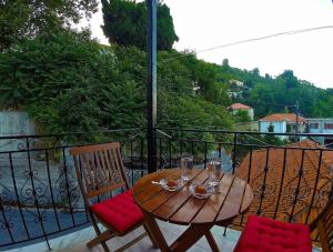 a wooden table and chairs on a balcony at Stavroula Rooms in Makrirrákhi