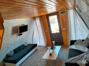 a living room with a couch and a table and a tv at Popasul Dacilor in Predeluţ