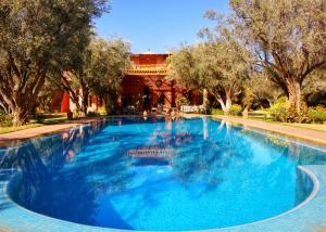 una gran piscina de agua azul frente a un edificio en GreenLife Marrakech en Marrakech