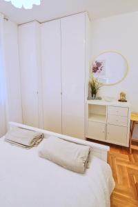 a white bedroom with a bed and a mirror at Lovely apartment MIRA near Airport Zagreb in Velika Gorica