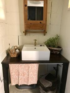 a bathroom with a white sink and a mirror at Travelers House おーさんてぃん青空舎 in Taketomi +37 photos