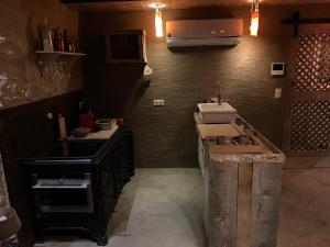 a kitchen with a counter and a sink and a stove at Boutique Cottage - Sauna and Jacuzzi - El Clandestino in Érezée +11 photos