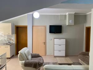 a living room with a couch and a tv on the wall at Cozy GuestHome Korce in Korçë