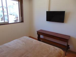 1 dormitorio con 1 cama y TV en la pared en Hermoso departamento en San Telmo en Buenos Aires