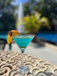 a blue drink in a martini glass on a table at The Palms At Coco Beach in Coco