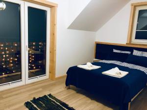 a bedroom with a blue bed with two towels on it at Babiakówka in Kluszkowce