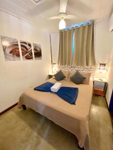 1 dormitorio con 1 cama grande y ventana en Vila Pequeá Ilhabela en Ilhabela