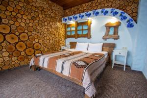 1 dormitorio con cama y pared de troncos en Poeziya Mandriv, en Skhidnytsya