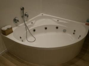 a white bath tub with a shower in a bathroom at Mikiway סוויטה פנורמית בגלבוע in Bet HaShitta