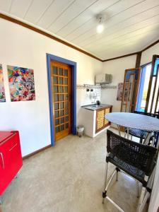 Habitación con mesa y cocina en Vila Pequeá Pousada Ilhabela, en Ilhabela