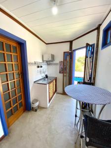 a kitchen with a table and a table and chairs at Vila Pequeá Pousada Ilhabela in Ilhabela