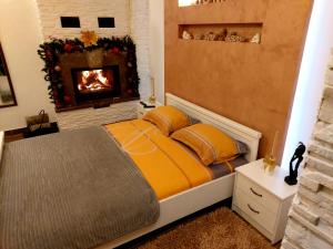 een slaapkamer met een bed en een open haard bij Apartmani vuk in Cetinje
