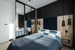 ein Schlafzimmer mit einem Bett und einem großen Spiegel in der Unterkunft Apartament Słoneczniki Cieplice in Jelenia Góra