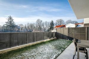 eine Terrasse mit einem Tisch und Stühlen auf einem Zaun in der Unterkunft Apartament Słoneczniki Cieplice in Jelenia Góra