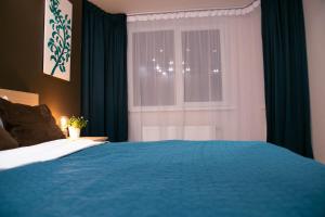 a bedroom with a blue bed and a window at Brassy apartment in Riga