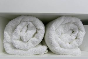 two rolls of white towels sitting on a shelf at Brassy apartment in Riga