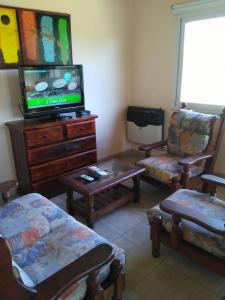 - un salon avec une télévision sur une commode en bois dans l'établissement Piscu Yaco, à Santa Rosa de Calamuchita 15 autres photos