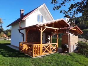 a house with a wooden deck in front of it at Deda Simina vikendica in Pale