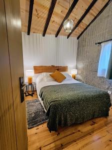 um quarto com uma cama grande num quarto com pisos em madeira em Casa Ribeiro em Sabugueiro