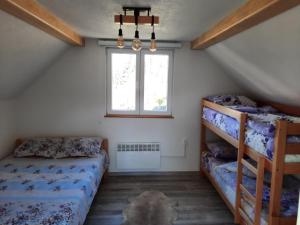 a bedroom with two bunk beds and a window at Deda Simina vikendica in Pale +30 photos