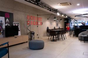 Zimmer mit einem TV, einem Tisch und Stühlen in der Unterkunft ibis Styles Nancy Centre Gare in Nancy