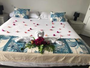 a bed with two swans and roses on it at Tahiti Moetama Cosy Lodge - VILLA ITI in Punaauia