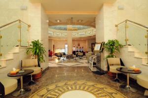 a lobby of a hotel with tables and chairs at Dar Al Naem Hotel in Medina