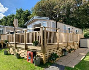 a large wooden house with a large deck at Lydstep Beach BayView 3-Bedroom Holiday Home in Tenby