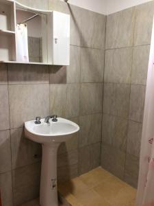 a bathroom with a sink and a mirror at CABAÑAS FENIX con ARROYO NATURAL BORDEANDO LA PROPIEDAD reservar con 24 hs de anticipación in Villa Amancay