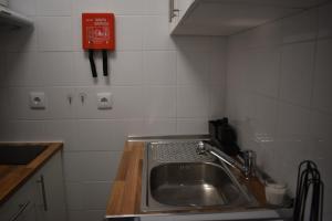 a kitchen with a sink and a red sign on the wall at Lagoa House - Casa típica Algarvia in Lagoa +26 photos