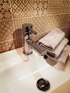 um lavatório de casa de banho com torneira e toalhas em Uscio e bottega em Montepulciano