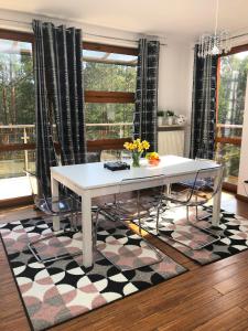 a white table and chairs in a room with a rug at Apartament z prywatnym tarasem na dachu Ogień 8 Jurata in Jurata