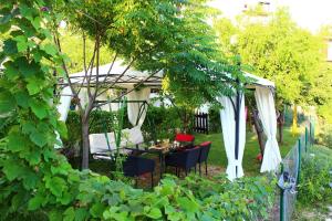 einen Garten mit einem Pavillon, einem Tisch und Stühlen in der Unterkunft Apartments Petrada in Omiš