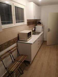 a kitchen with a microwave and a chair and a refrigerator at White Night in Skopje
