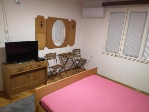 a bedroom with a bed and a table and chairs at White Night in Skopje