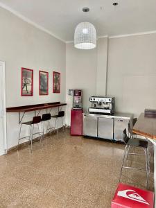 a kitchen with a counter and stools in a room at Hostel Playa Grande Austral in Mar del Plata